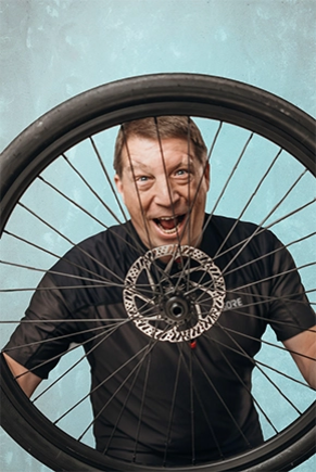Mann im Sportshirt mit Fahrradreifen