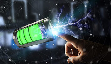 Leuchtende, gefüllte Batterie gibt Strom an einen Finger ab