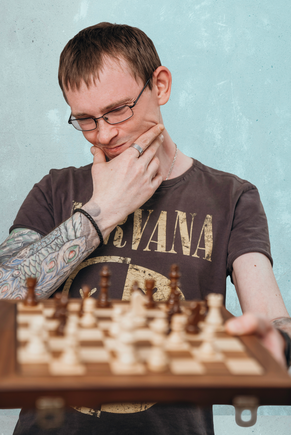 A man looks thoughtfully at a chessboard