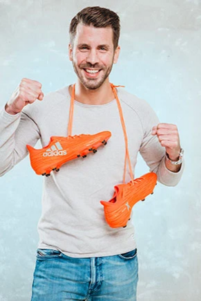 Man with orange football shoes cheering