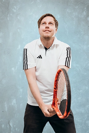 Mann im Tennisshirt hält einen Tennisschläger