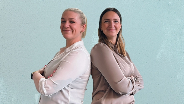 2 Frauen stehen mit verschränkten Armen Rücken an Rücken