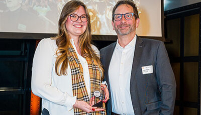 Eine Mitarbeiterin und der Geschäftsführer von Battery-Kutter posieren mit dem Service Award 2026