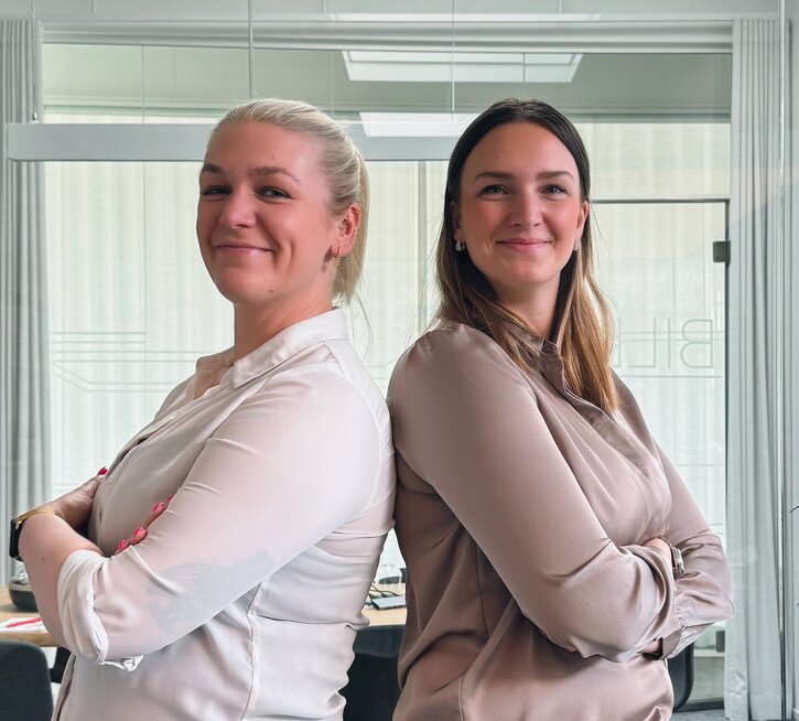 Zwei Frauen stehen Rücken an Rücken mit verschränkten Armen