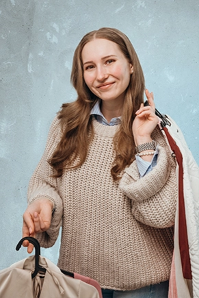 Frau in Pullover trägt Kleidung und Einkauftüten