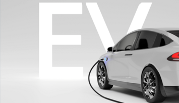 An electric car with a cable connected whilst charging, against a grey background.