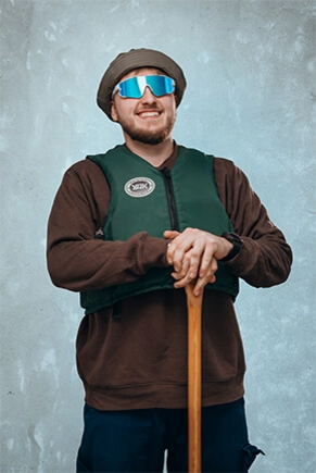Mann mit Hut, Sonnenbrille, Schwimmweste und Kanupaddel