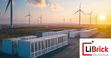 Batteriespeicher und Windräder vor einem Sonnenuntergang