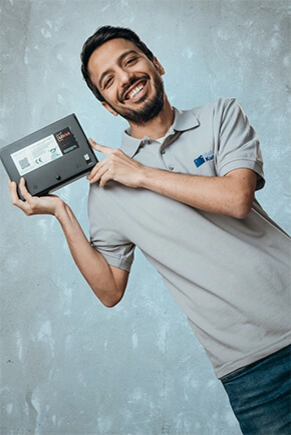 Mann in grauem Polo und Lithium-Akku in der Hand