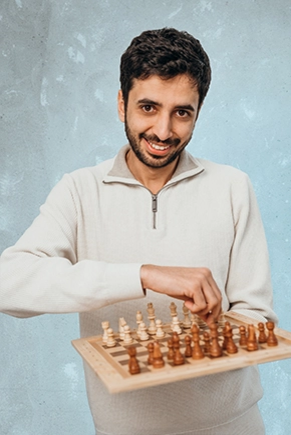 Mann hält Schachbrett in die Kamera