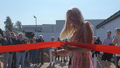 Woman cuts through a red ribbon